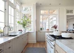 a kitchen with an oven, sink and windows