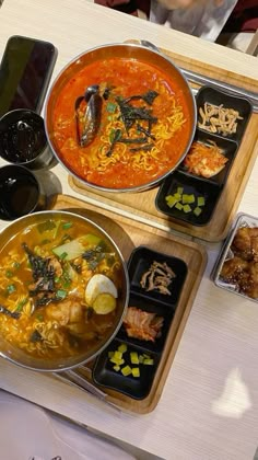 two bowls of food are sitting on trays