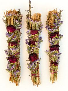 three bundles of dried flowers are arranged together