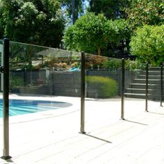 an empty swimming pool surrounded by trees and fence