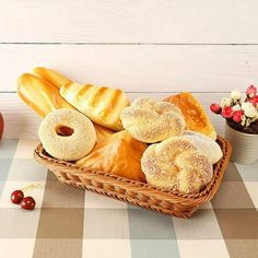 a basket filled with lots of different types of doughnuts on top of a checkered table cloth