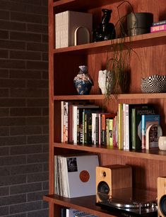 the bookshelf is filled with many different types of audio and record player's