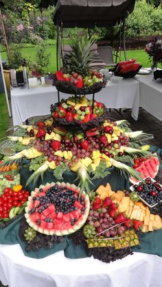 a table filled with lots of different types of fruit on top of white tables cloths