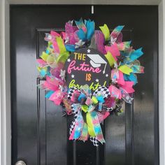 a colorful wreath with the words future is bright and decorated with ribbons on it's front door