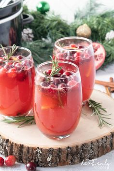 three glasses filled with cranberry punch on top of a wooden board