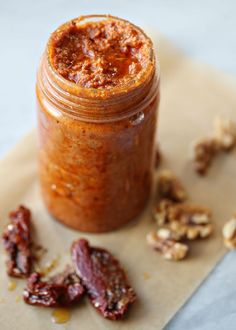 a jar filled with some kind of food on top of a paper towel next to nuts and raisins