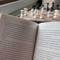 an open book sitting on top of a chess board