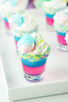 cupcakes with sprinkles and white frosting are on a tray