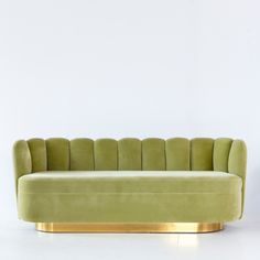 a green couch sitting on top of a white floor