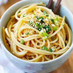 a close up of a bowl of noodles with chopsticks