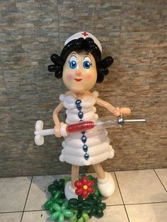 a statue of a nurse holding a syringe in her hand and standing on a tile floor