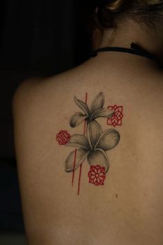 a woman's back tattoo with flowers on it