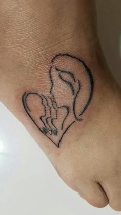 a woman's foot with a small tattoo of a heart and a dog on it