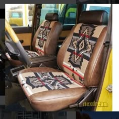 the interior of a yellow truck with native american designs on it's seat covers