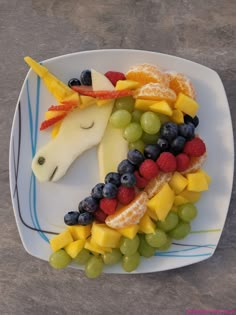 a white plate topped with fruit and a horse head