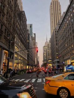 a city street filled with lots of traffic and tall buildings in the evening light hours