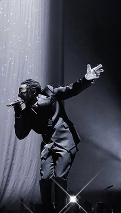 a man standing on top of a stage holding a microphone