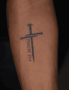 a cross tattoo on the leg of a person with a knife in it's hand