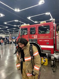 a woman in fire fighter gear walking through a building