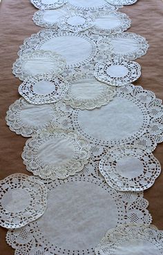 several white doily laid out on the ground with one being used as a table runner