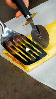 a person using a knife to cut up food on top of a piece of paper