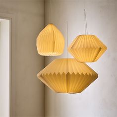 three yellow paper lamps hanging from the ceiling