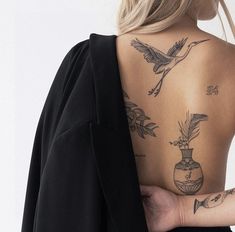 the back of a woman's body with tattoos on it