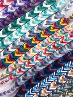 several different colored knitted fabrics are stacked together on top of each other in rows