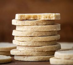 a stack of shortbread cookies sitting on top of a wooden table next to sliced bananas