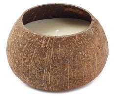 a close up of a candle in a coconut shell on a white background with clippings