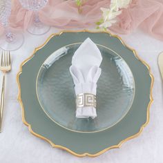 a table setting with napkins, silverware and flowers