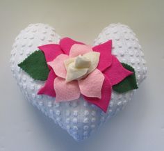 a white heart with a pink flower on it