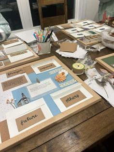 the table is covered with papers and other crafting supplies, such as pencils