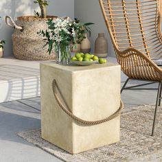 a table with some fruit on top of it next to a chair and potted plant