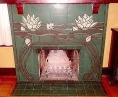 the fireplace is decorated with green tiles and white flowers