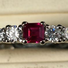 an engagement ring with three stone diamonds and a pink tourmaline