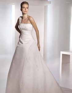 a woman in a white wedding dress posing for the camera with her hands on her hips