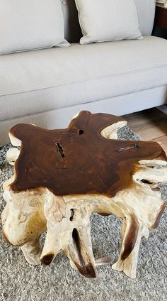 a wooden table sitting on top of a carpeted floor next to a white couch