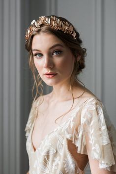 a woman wearing a bridal headpiece with leaves on her forehead and hair comb