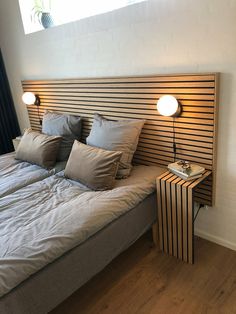 a bed with two lamps on either side of the headboard and an end table next to it