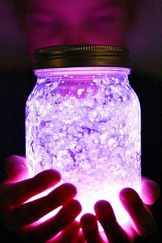 a person holding a glowing jar in their hands