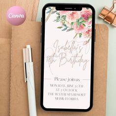 an iphone with a floral birthday card on it next to a pen and notepad