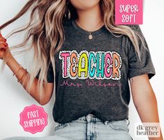 a woman wearing a t - shirt with the word teacher in colorful letters on it