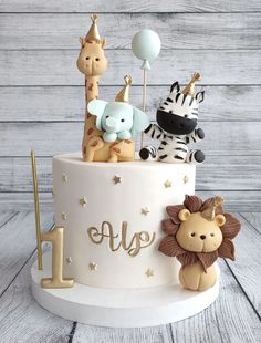 a birthday cake decorated with animals and balloons