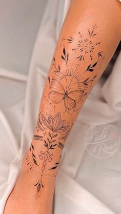 a woman's leg with flowers and butterflies tattoo on her left calf sleeve, which is covered in black ink