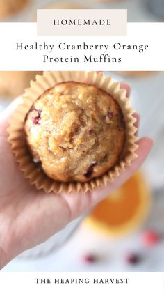 a person holding a muffin in their hand with text overlay that reads homemade healthy cranberry orange protein muffins