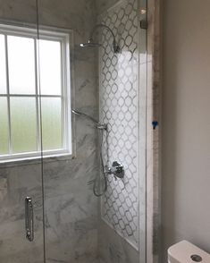 a bathroom with a walk in shower next to a window