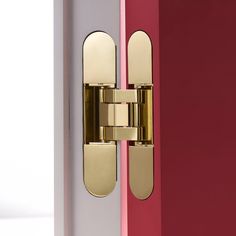 a close up of a door handle on a red and white door with pink walls