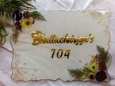 a white and gold plate with the words happy birthday 1044 on it, surrounded by flowers