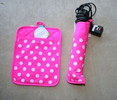 a pink and white polka dot covered case next to a black corded phone charger